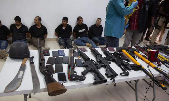 Vũ khí thu giữ từ nhóm nghi phạm vụ ám sát Tổng thống Haiti Jovenel Moise xếp trên bàn tại buổi họp báo ở Port-au-Prince hôm 8/7. Ảnh:AP.